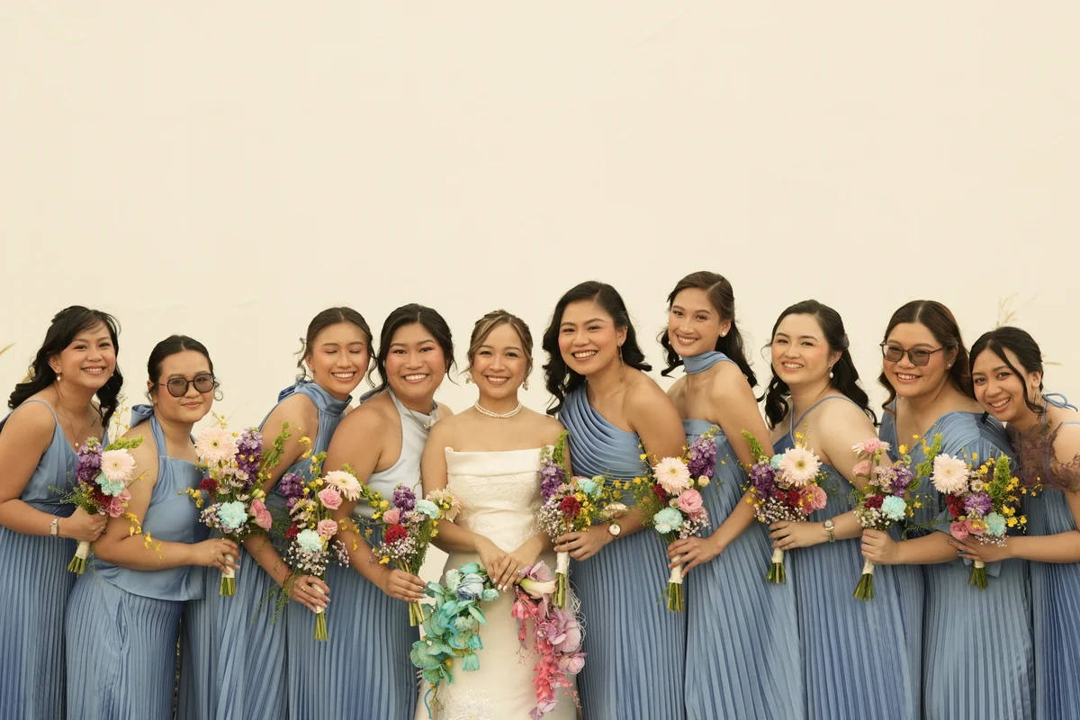 Bride and bridal party in blue dresses with flowers